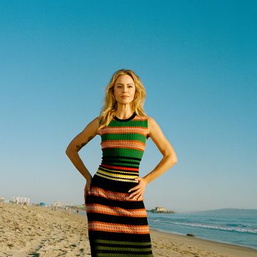a woman in a striped dress on a beach