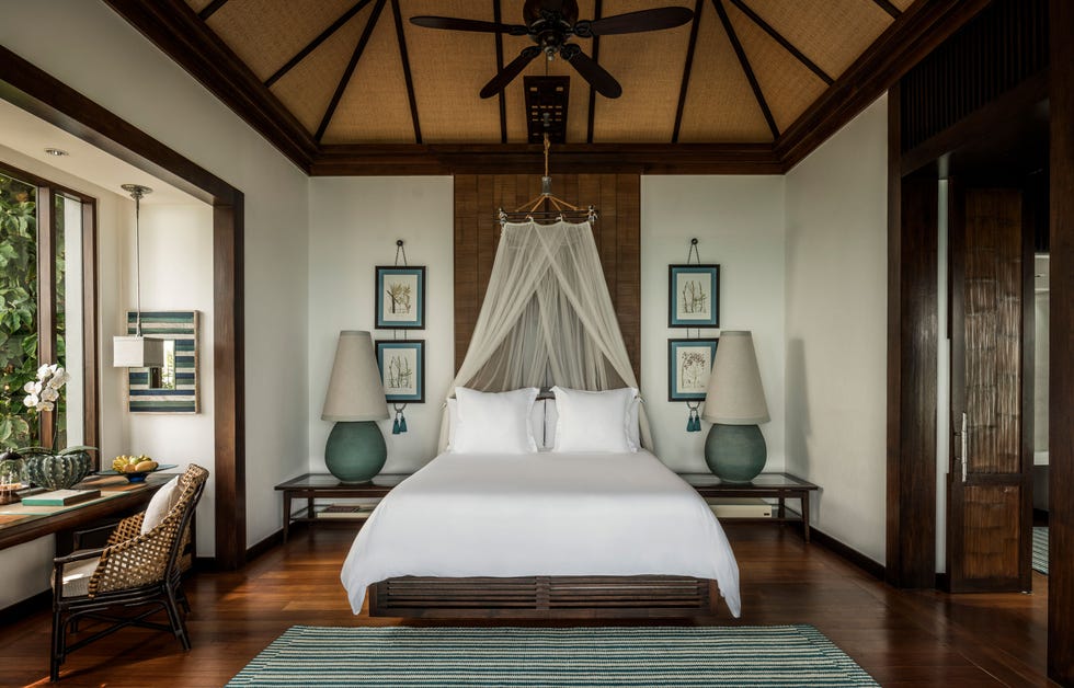 tropical bedroom featuring a large bed with a mosquito net and decorative elements