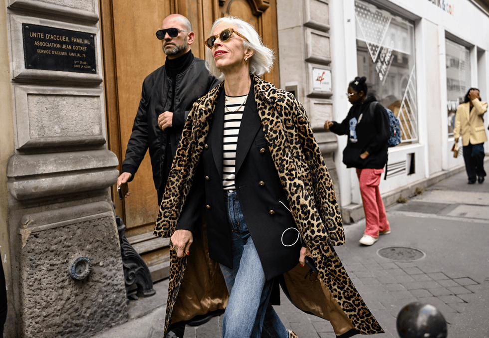 a woman with white hair wearing a leopard coat