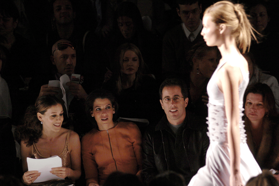 people watching a model walk the runway