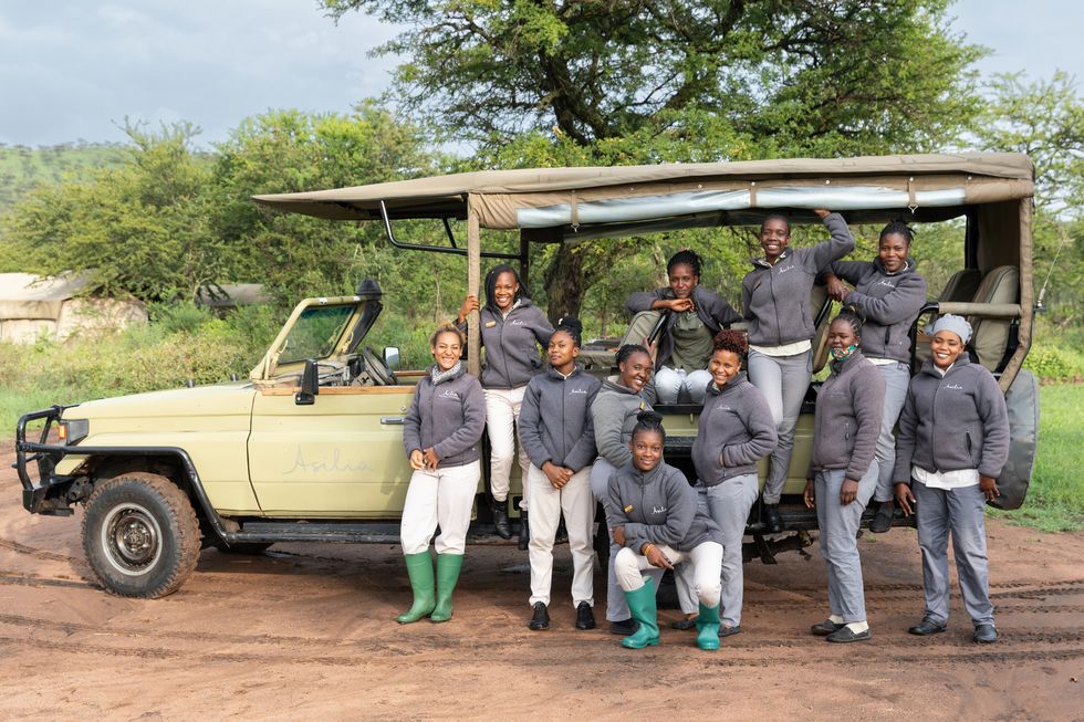 the only camp of its kind on the continent, dunia boasts an all female staff chefs, waitresses, managers, and guides who pose in front of the nearly indestructible land cruiser used on game drives