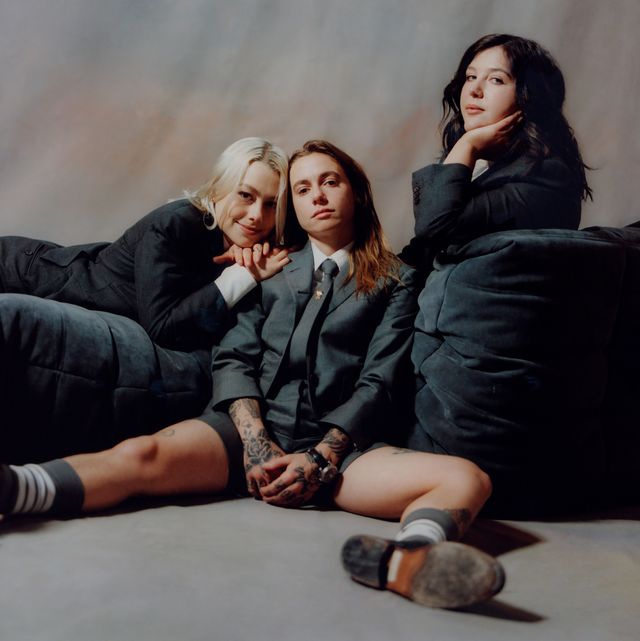 a group of women in gray clothing sitting on the ground
