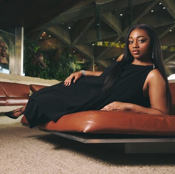 A person reclining on a modern leather sofa in a stylish indoor setting A person reclining on a modern leather sofa in a stylish indoor setting