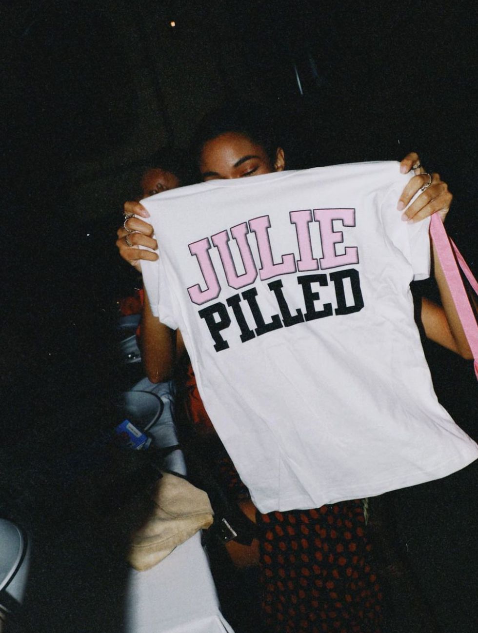a person holding a t shirt that reads julie pilled