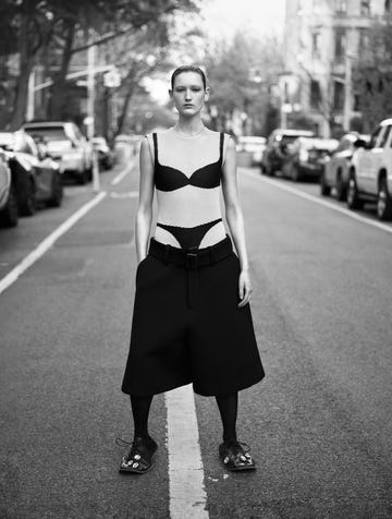 a woman standing in the middle of a street wearing shorts and a trompe l'oeil bra and underwear top