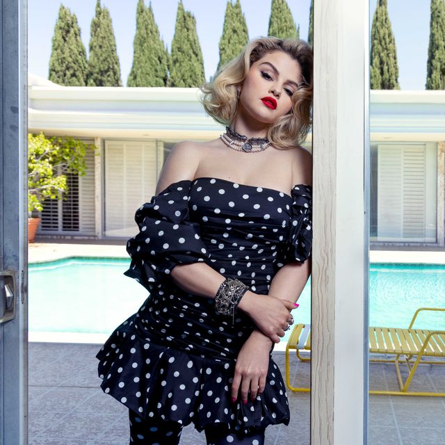 selena gomez stands in front of a swimming pool wearing a polka dot minidress