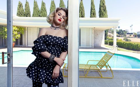 selena gomez stands in front of a swimming pool wearing a polka dot minidress