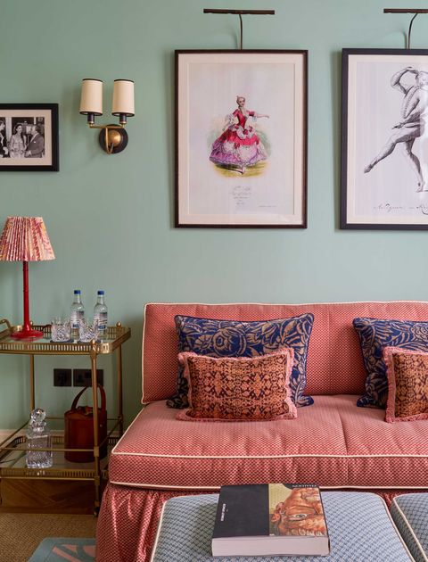 a hotel suite with art prints and a salmon sofa