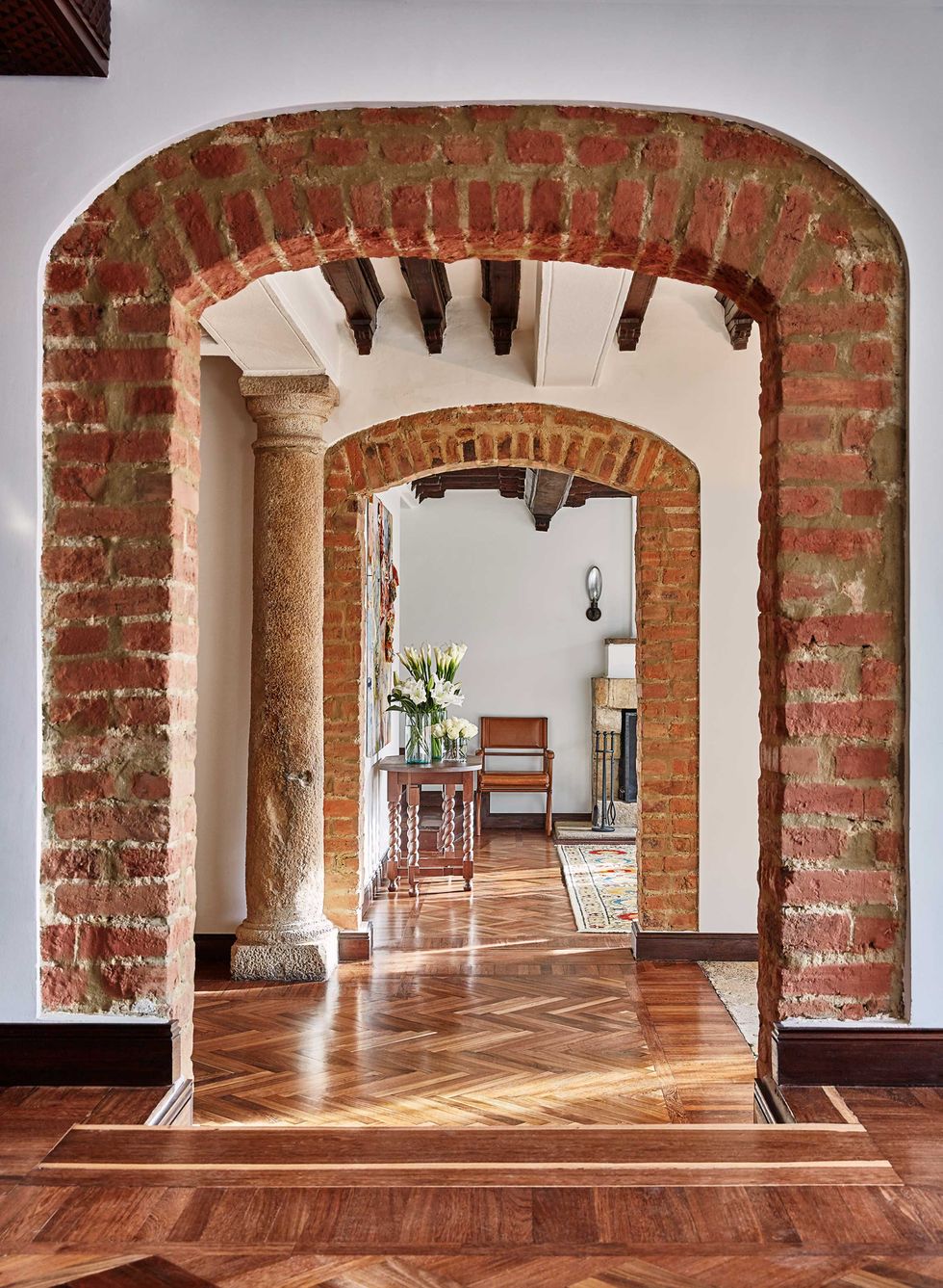 an interior view of a hotel common area through an exposed brick archway