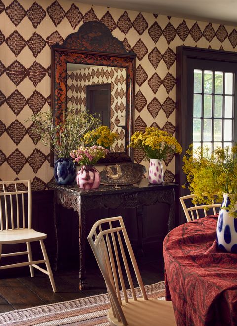 the dining room, with walls covered with thin strips of ikat fabric, doubles as a revolving gallery for arnhold’s glass designs