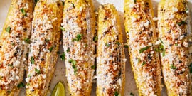 grilled corn topped with a creamy mixture, cotija cheese, chili powder, cilantro and lime