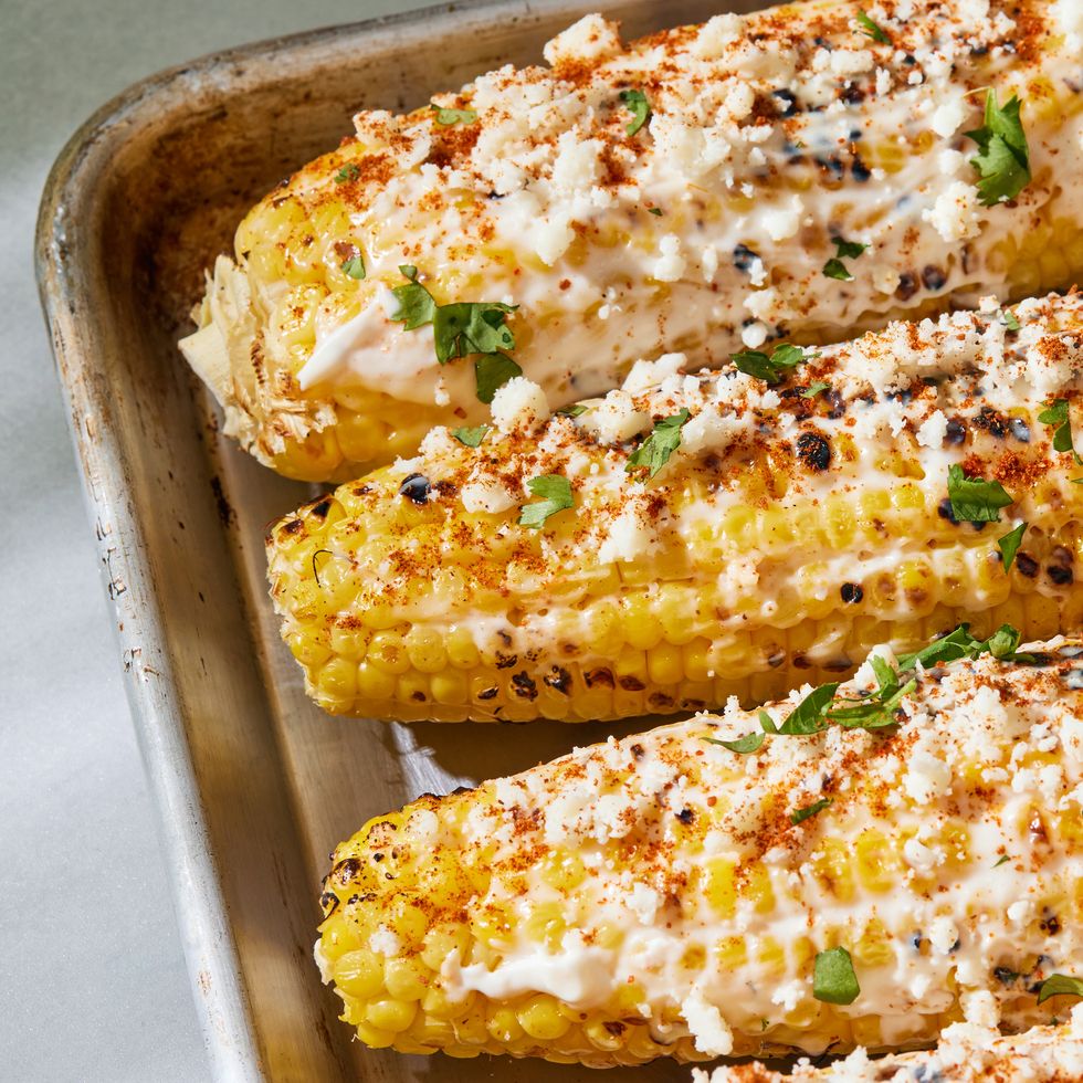 grilled corn topped with a creamy mixture, cotija cheese, chili powder, cilantro and lime
