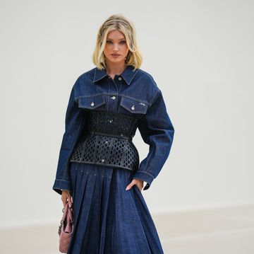 paris, france september 27 elsa hosk wears a navy blue denim shirt  pleated long dress from dior, a black shiny leather mesh corset from dior, a pale pink shiny leather lady d light handbag from dior, outside dior, during paris fashion week womenswear springsummer 2023, on september 27, 2022 in paris, france photo by edward berthelotgetty images