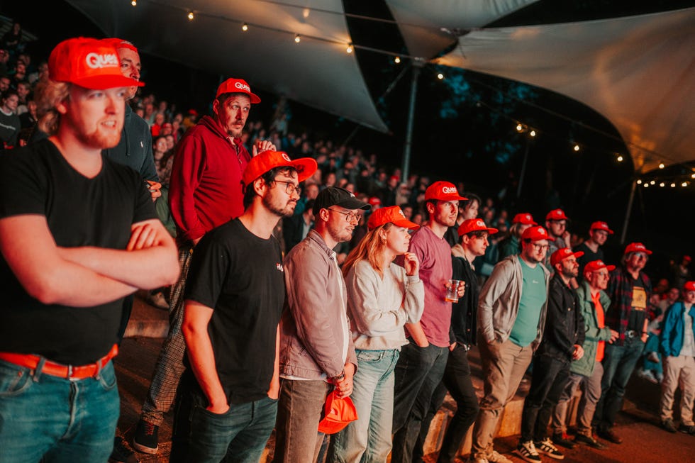 Photo of a large group of members of the public wearing red mission hats