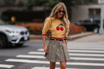 mujer con gafas de sol, jersey y minifalda