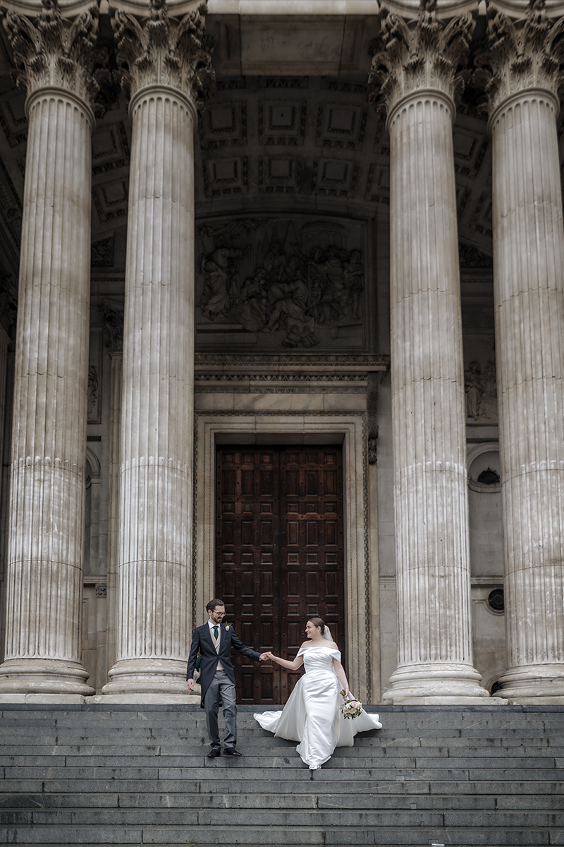 st pauls cathedral london wedding a bride and groom walking down the stairs