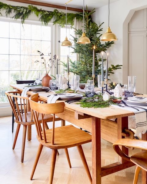 wood dining set with taper candles and greenery