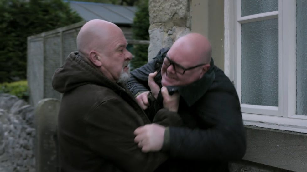 emmerdale, bear attacks paddy outside, pushing him up against a building by grabbing him by the collar