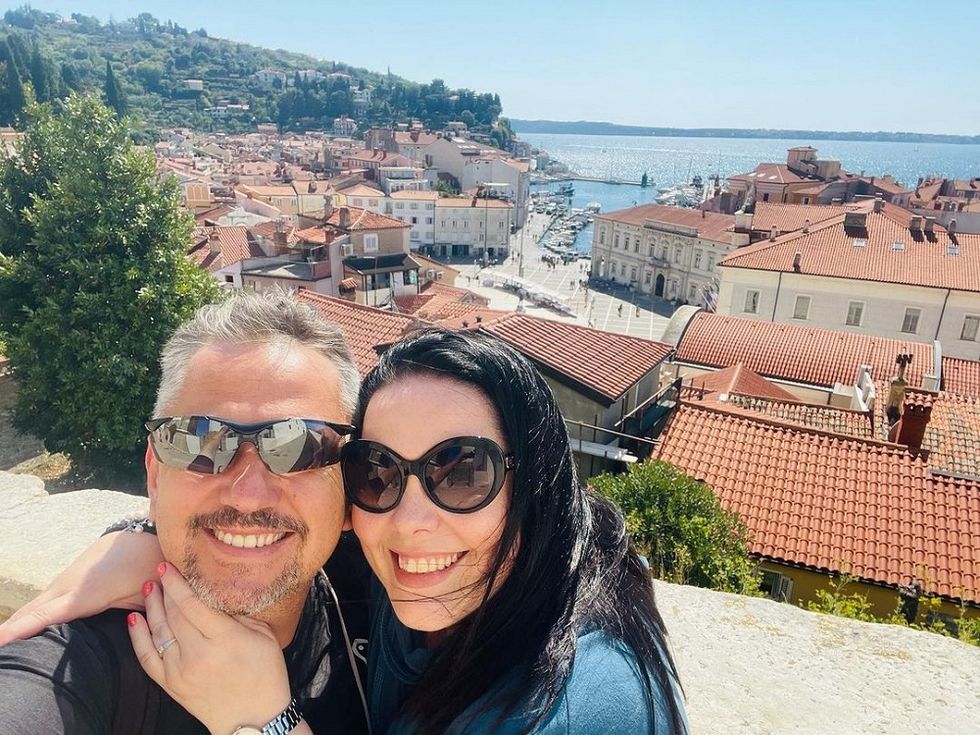emmerdale actress lisa riley and fiancé al smile in front of a harbour in slovenia, september 2021