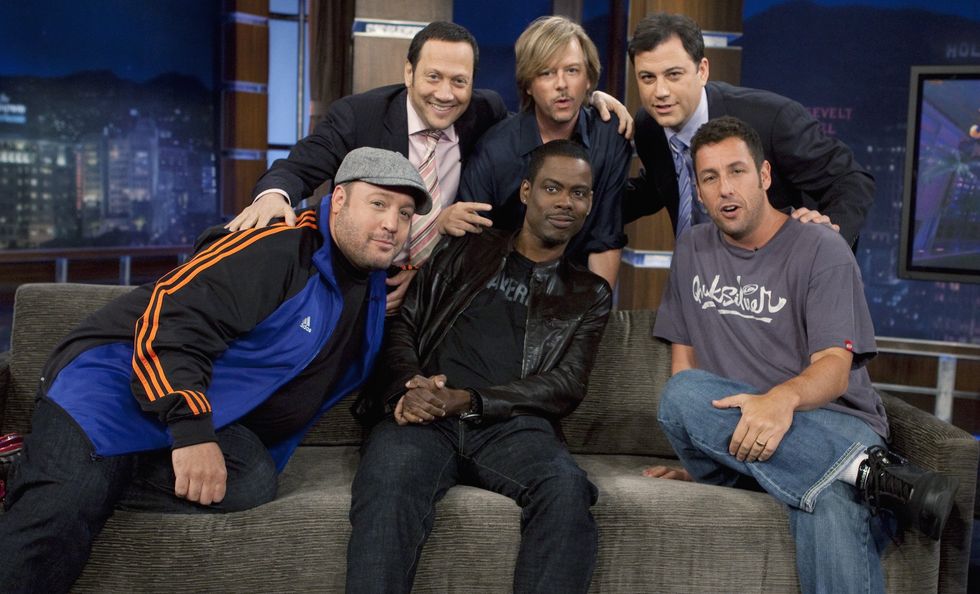 kevin james, chris rock, and adam sandler sit on a couch in front of rob schneider, david spade, and jimmy kimmel who are standing behind, in the background is a tv set for jimmy kimmel live