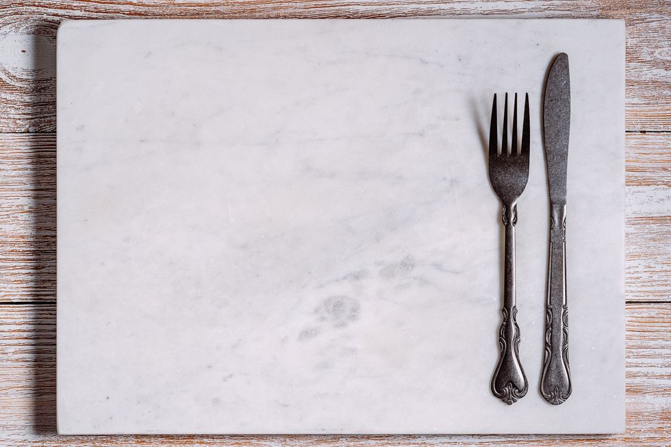 empty marble board with fork and knife
