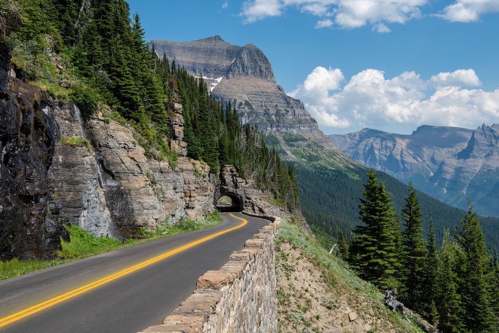 empty road along mountains against sky,glacier national park,montana,united states,usa