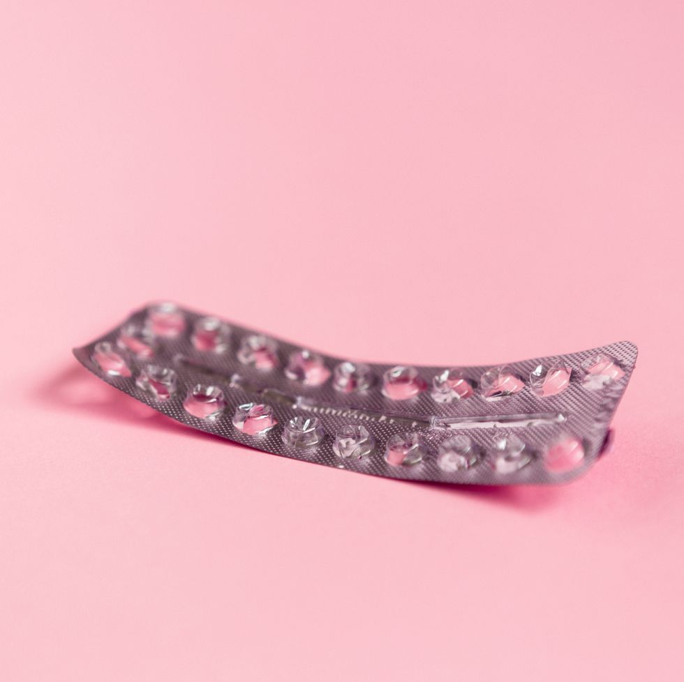 Empty strip of birth control pills on pink