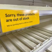 empty supermarket shelves apology sign in yellow