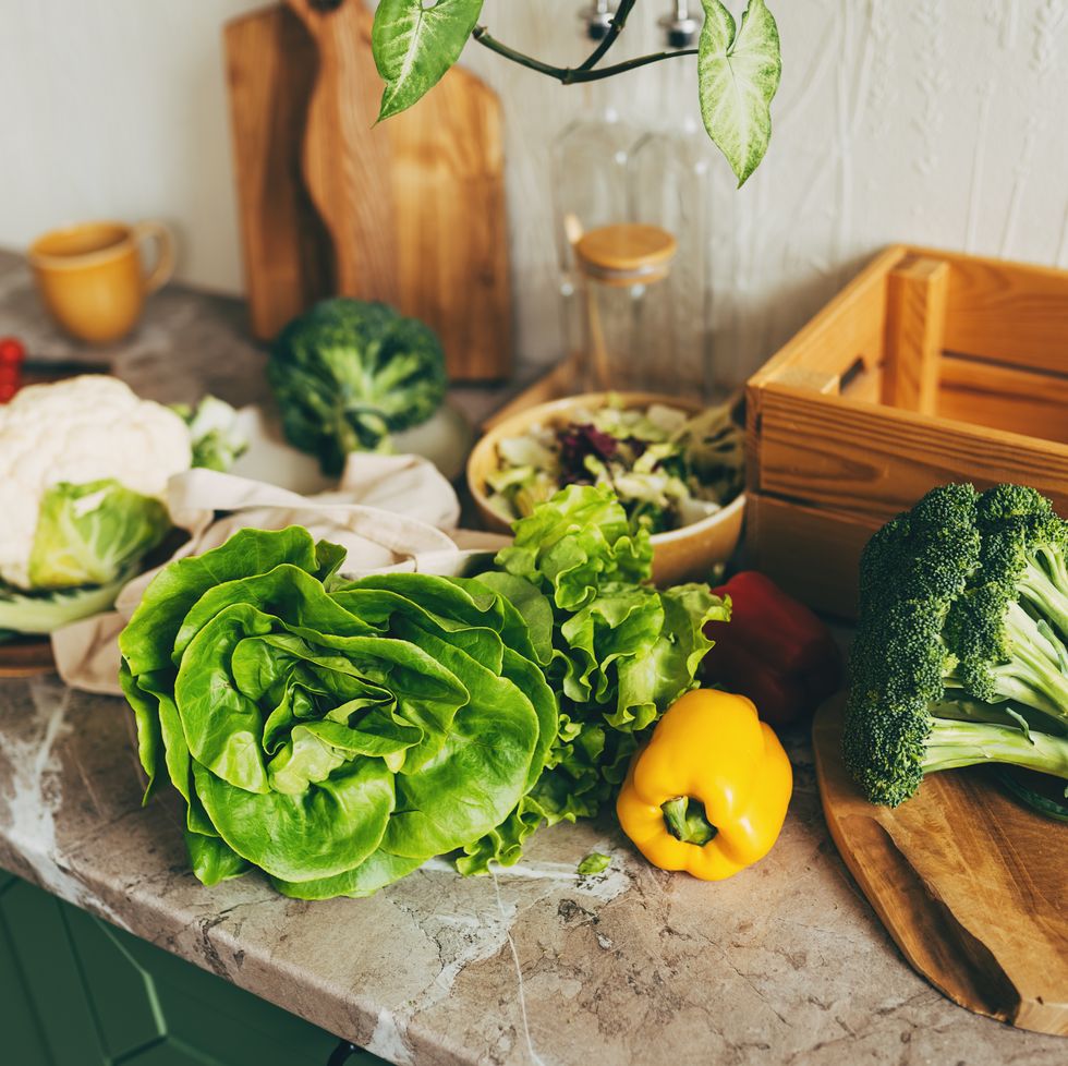 empty wooden table with blurred kitchen interior background. table with vegetables on top. table top product display showcase stage. image ready for montage your text or product.