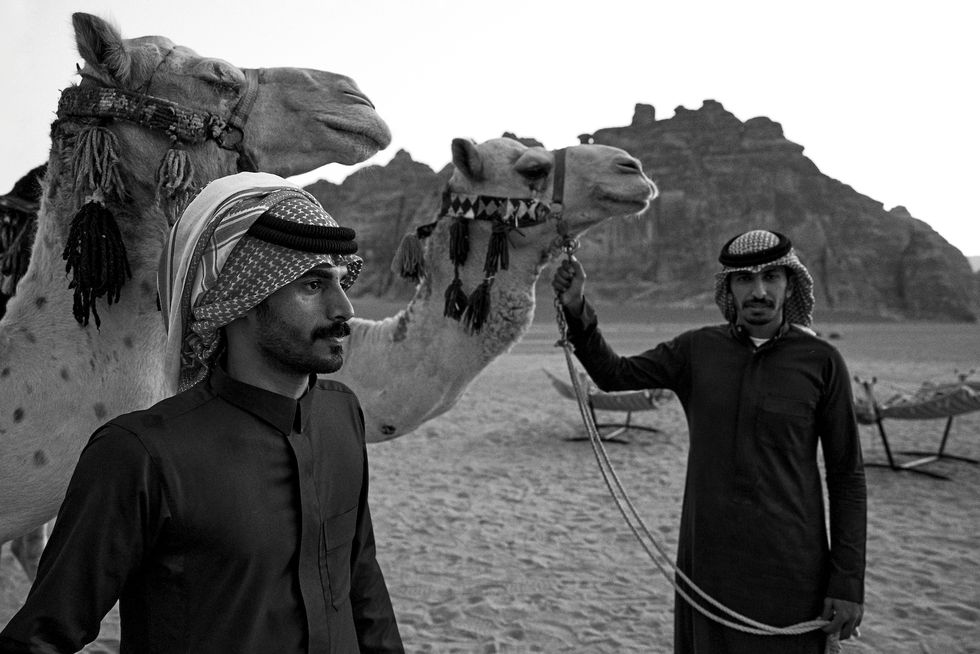 a couple of men with camels