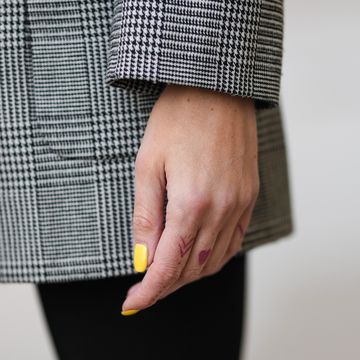 emy venturini in parijs met detail foto van hand met gele nagels