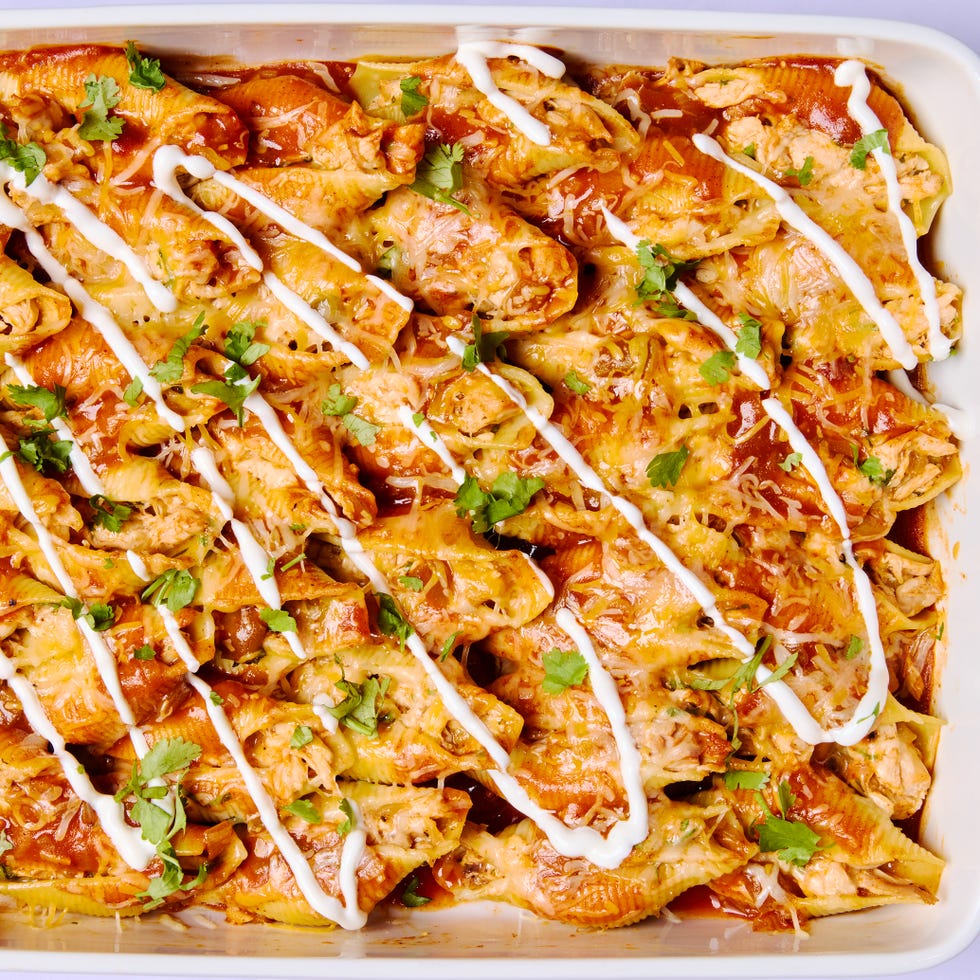 stuffed pasta shells with chicken, cheese, enchilada sauce, and a drizzle of sour cream
