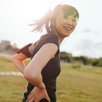 een vrouw lacht tijdens het hardlopen