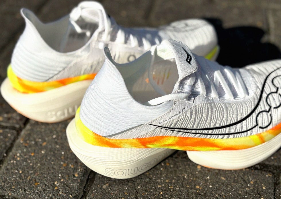 pair of white running shoes with yellow and orange details