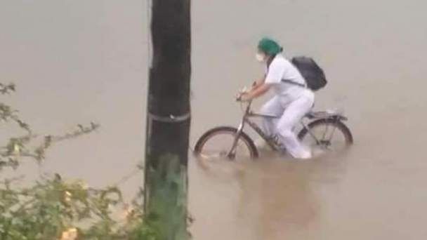 enfermera acude a su trabajo en bici en medio de una inundación en bolivia