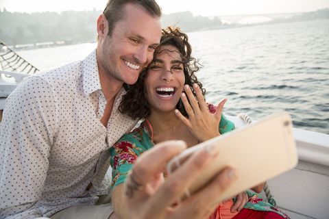 couple on boat showing off engagement ring
