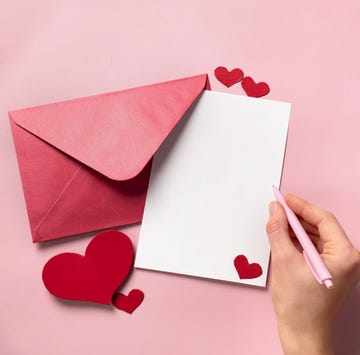 what to write in an engagement card person writing on heart decorated white paper in a red envelope