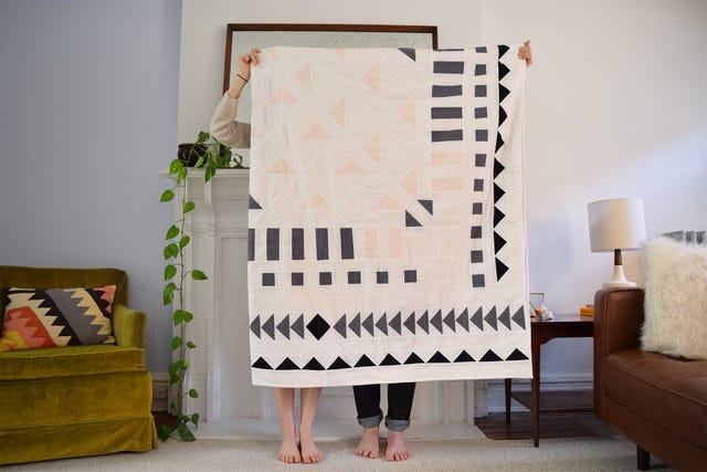 couple holding up their embroidered engagement blanket