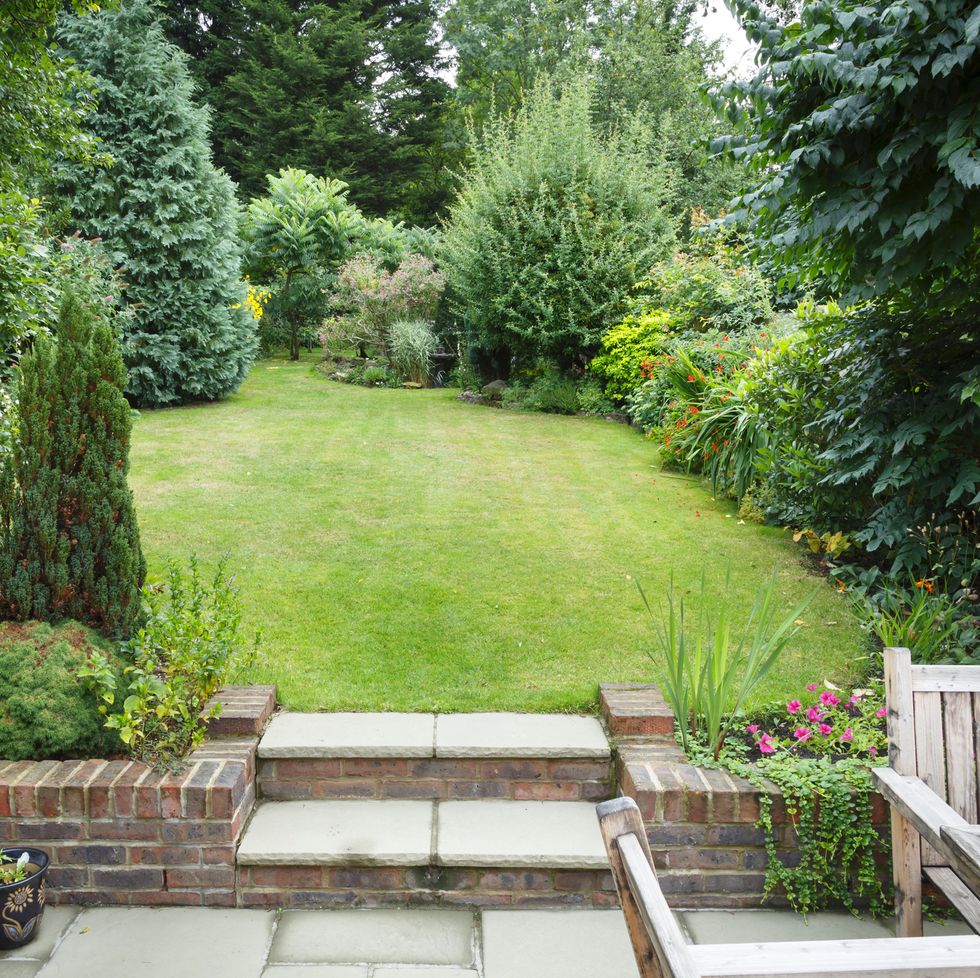 terraced and landscaped back garden in england uk with patio, grass and stone steps