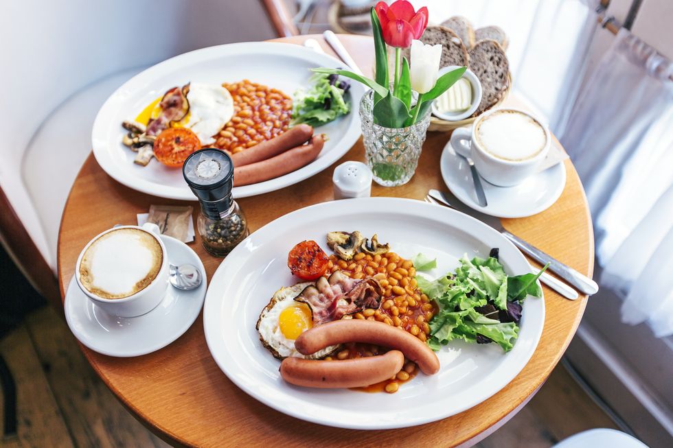 english breakfast with eggs, beans, bacon, sausages, mushrooms and tomatoes