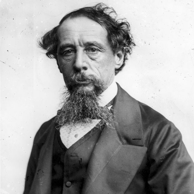 a black and white photograph of charles dickens wearing a suit and looking directly into the camera
