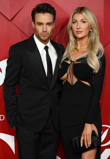 liam payne and kate cassidy pose together on red carpet, both wear black formal outfits