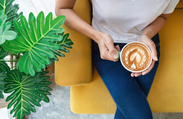 Coffee On The Go. Beautiful Young Woman Holding Coffee Cup And