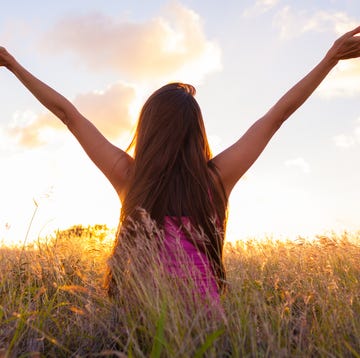 healing scriptures woman with her arms raised up facing the sun