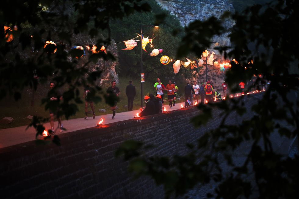 a group of runners at night with lanterns and lights