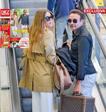 la pareja, con gafas de sol en unas escaleras mecanicas