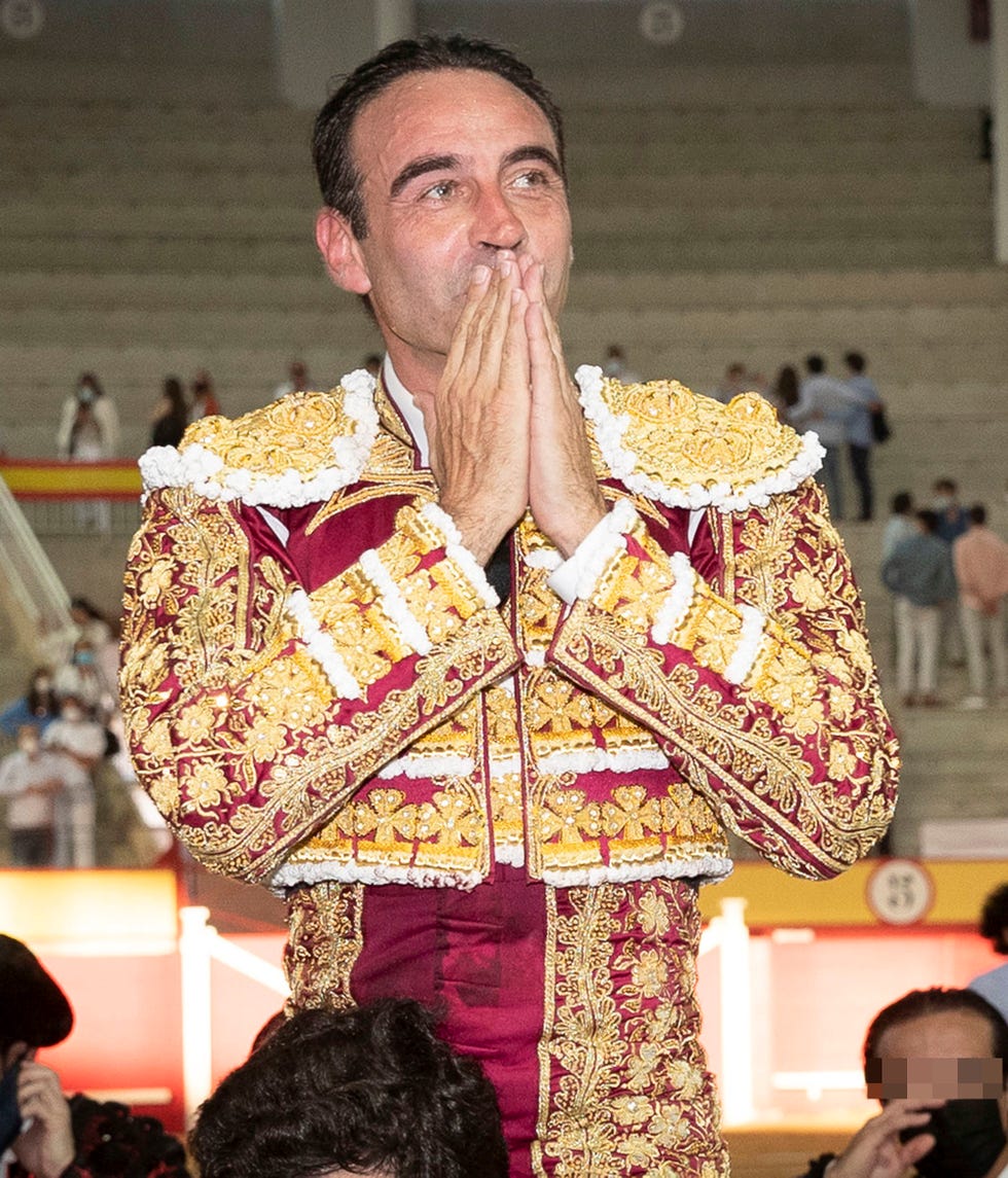 el torero, a hombros, lanza un beso al público que le aplaude