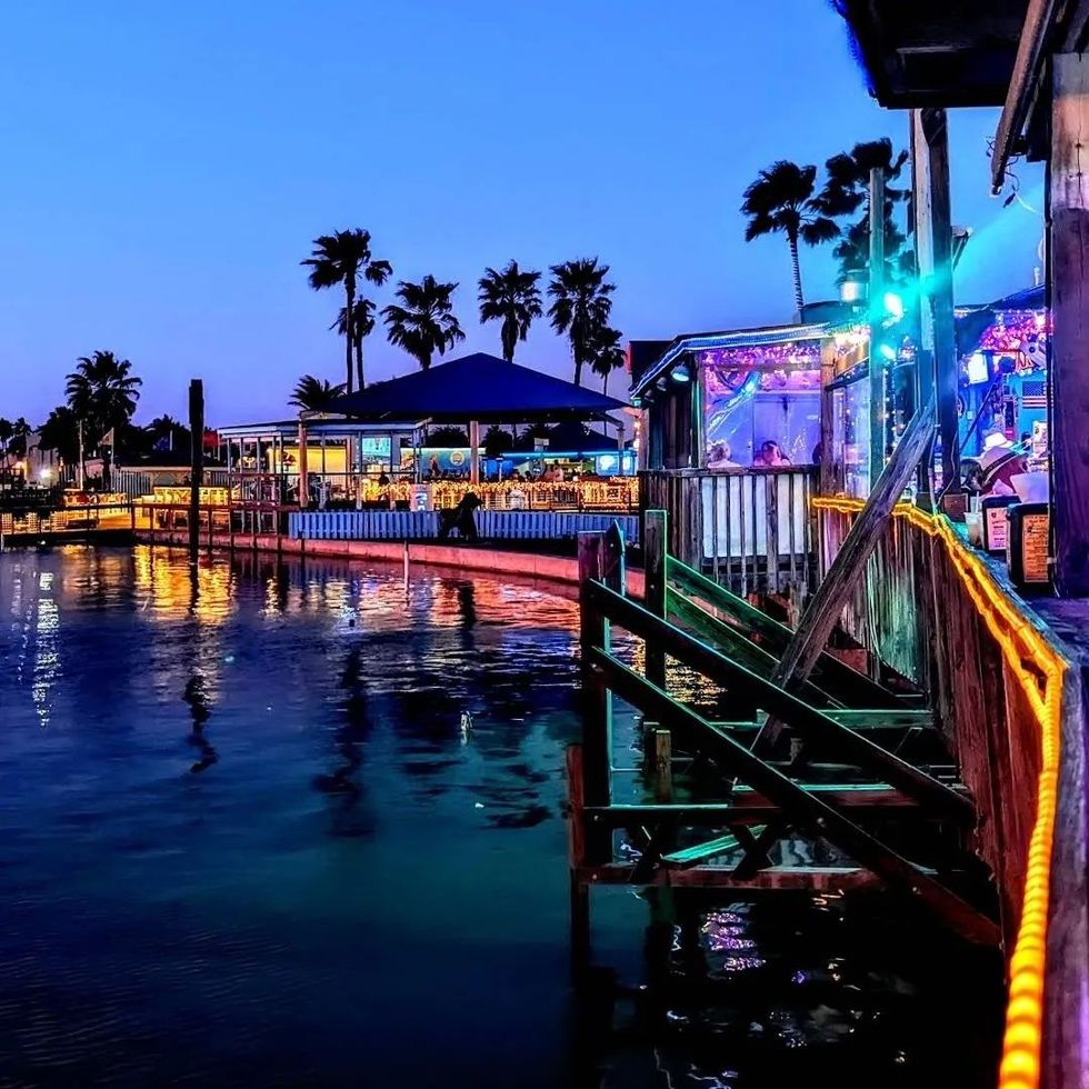 restaurants lit up with colorful lights on docks above the water