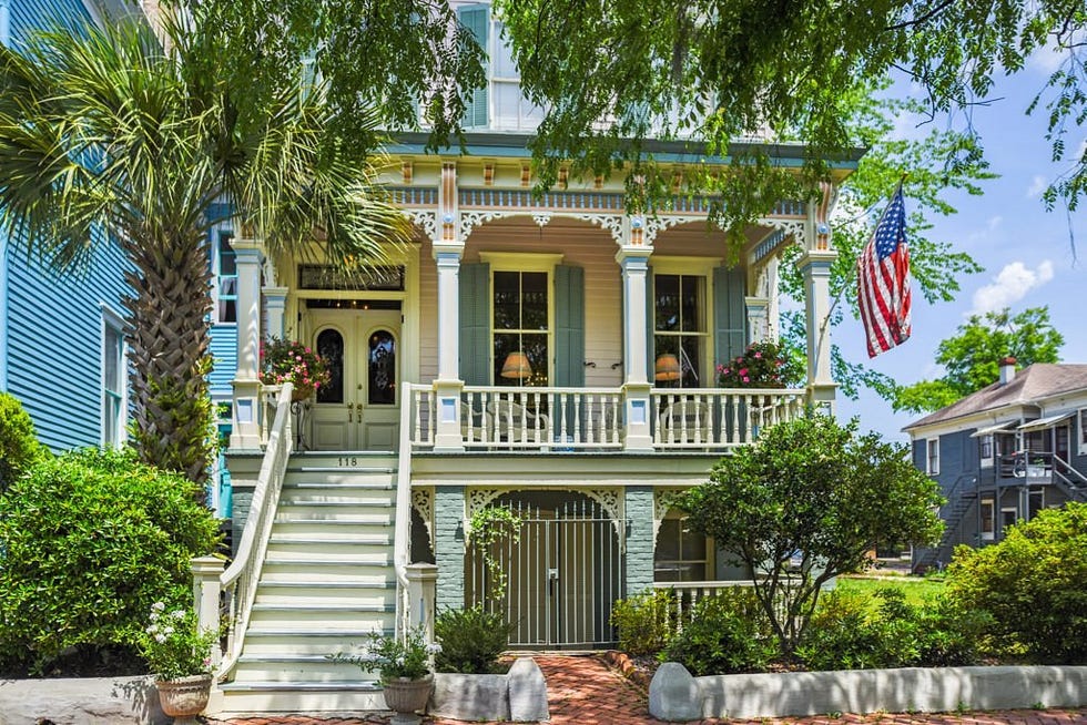 a house with a flag on the porch with garden district in the background