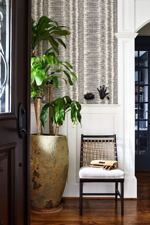 entryway with a chair and black hands on the wall that are key holders